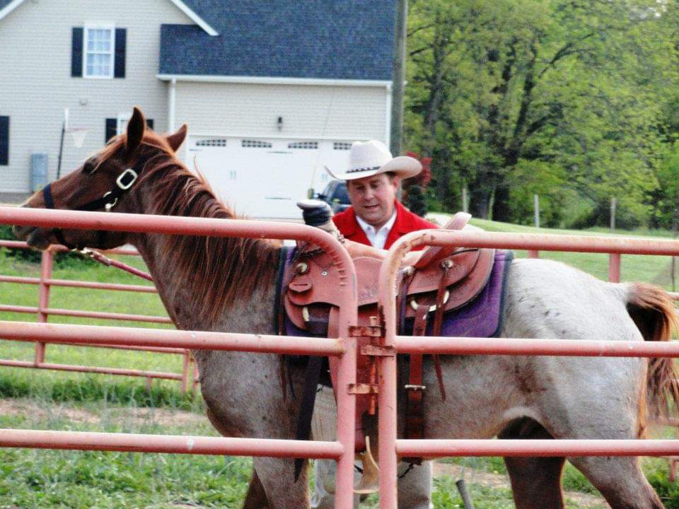 A ranch leader saddling a horse